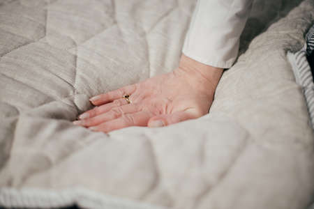 Woman s hand pressing on white mattress. Checking hardness and softnessの写真素材