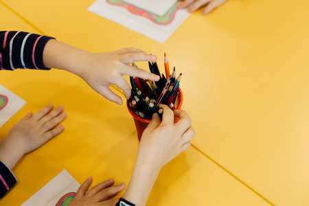 children's hands with drawings and colored pencilsの写真素材