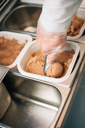 The seller puts a ball of ice-creamby scoopの写真素材