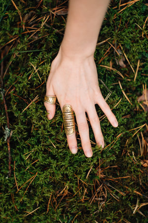 hand with rings on moss backgroundの写真素材