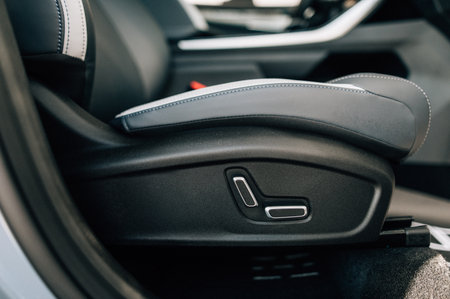 Close-up of luxury car seat adjustment buttons, showcasing sleek and modern automotive interior...