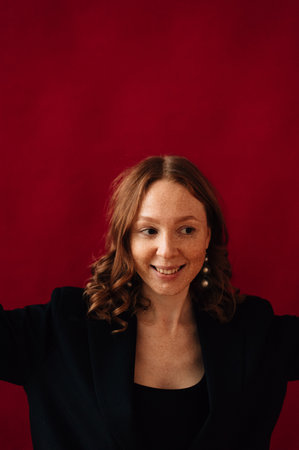 redhead girl smiling on red background. High quality photoの写真素材