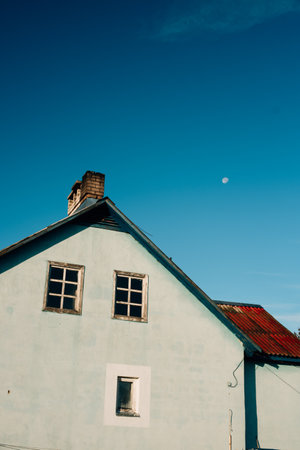 house against blue sky with moon. High quality photo