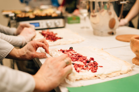 A pastry chef rolls up a meringue rollの写真素材