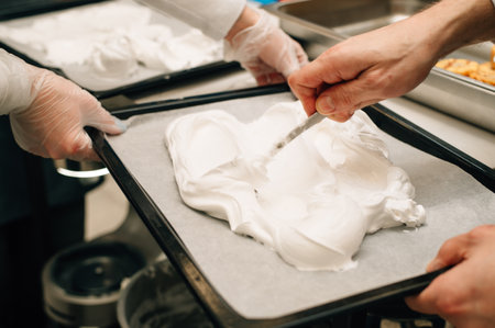 The confectioner spreads the meringue of a culinary silicone spatula. High quality photoの写真素材