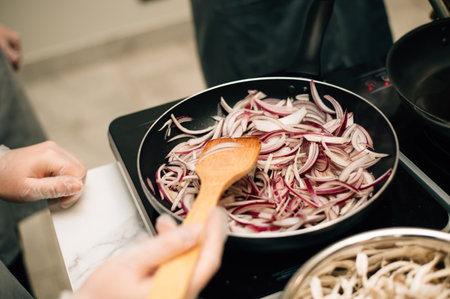 Onions are fried in a frying pan. High quality photoの写真素材