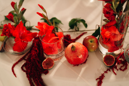 Wedding table decor. Pomegranates, burgundy flowers.の写真素材