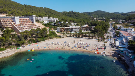 Aerial view of the beach of Port Sant Miquel on the north shore of Ibiza island in Spain - Isolated bay sided with large hillside hotels in the Balearic Islandsの写真素材