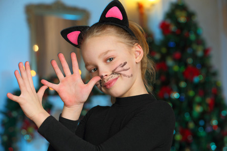 Pretty charming beautiful artistic blond baby girl in Christmas costumes. Beautiful blonde child girl in a carnival costume of a cat.の写真素材