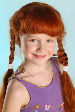 Close-up portrait of beautiful charming little redhead girl. Happy attractive child posing in a summer clothes. The pre-teen fashion model 8 years old.の写真素材