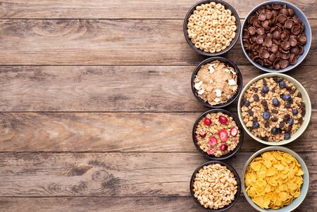 Breakfast cereals in bowls with on rustic wooden table, top view with copy spaceの写真素材