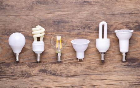 Different kinds of light bulbs on wooden background
