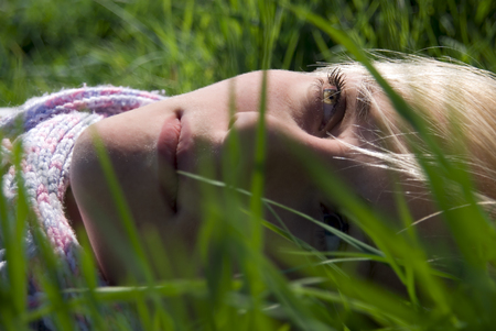 Portrait of the girl. In the spring on the nature in a grassの写真素材