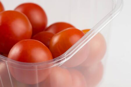 detail of a red cherry tomatoes in a transparent plastic boxの写真素材