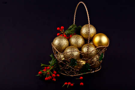 Christmas baubles in a decorative basket on black backgroundの写真素材