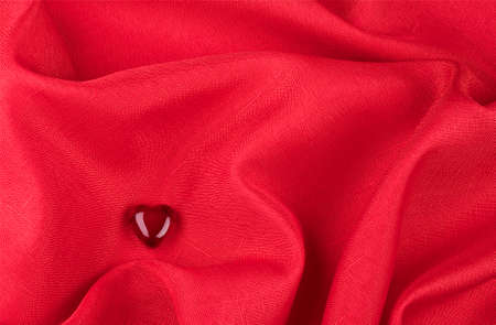 Heart of glass on the red fabric の写真素材