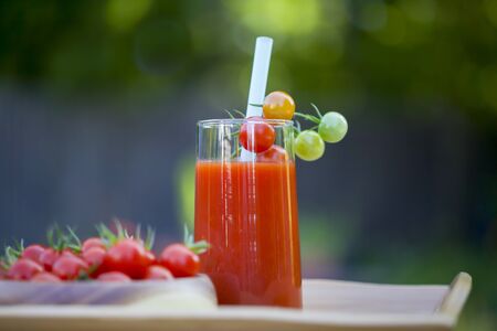 Cherry tomatoes and a glass of tomato juice.の写真素材