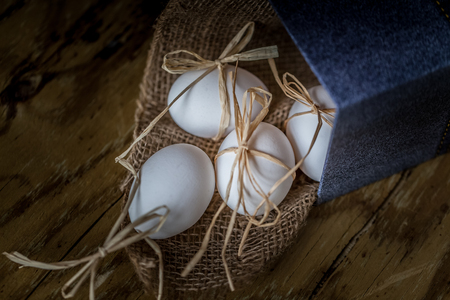 White eggs tied whit a straw, wooden background selective focus image.