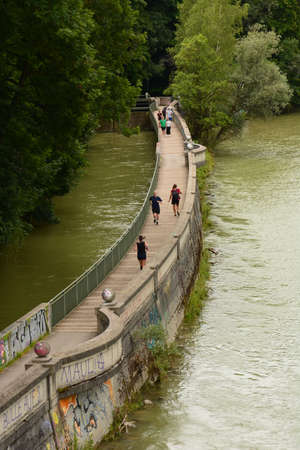 People walking on a pedestrian bridge over the Wroclaw river.の写真素材