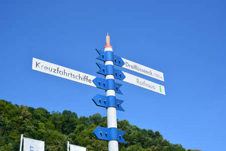 Signpost with directions to different cities on the background of blue skyの写真素材