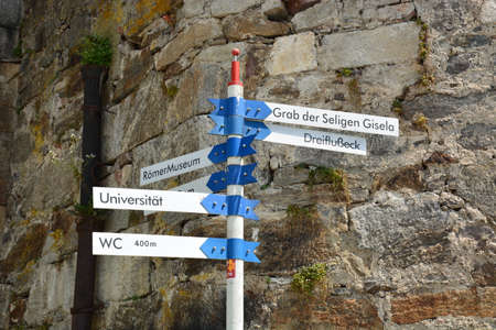 Directional signpost in front of a stone wall in Switzerlandの写真素材