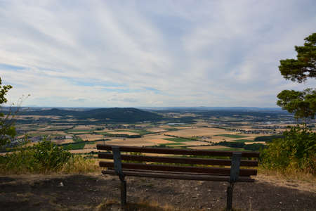 A bench on the top of a hill overlooking the valley and the countrysideの写真素材