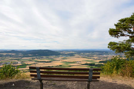 A bench on the top of a mountain with a view of the valleyの写真素材
