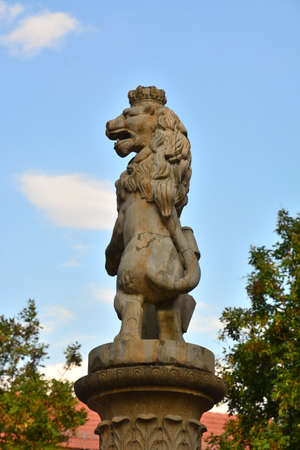 Statue of a lion on a pillar in the city park.の写真素材