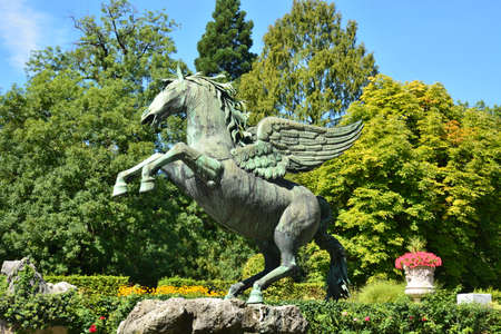 Statue of a horse with wings in the city park on a sunny dayの写真素材