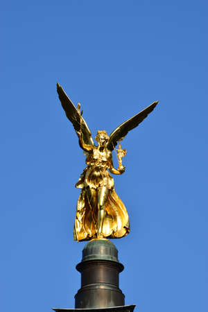Golden sculpture of an angel on the top of a monument in Frankfurt, Germanyの写真素材