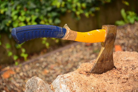 Axe stuck in a rock with a blue handle and a blue handleの写真素材