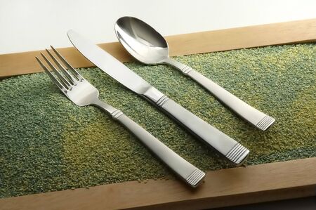 fork spoon and knife on the sand for decoration