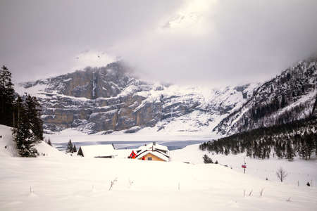 Mountain landscape with frozen lake on a cloudy day in Switzerlandの写真素材