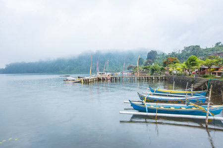 ship and mountain on river near ulun danu temple, bali , indonesiaの写真素材
