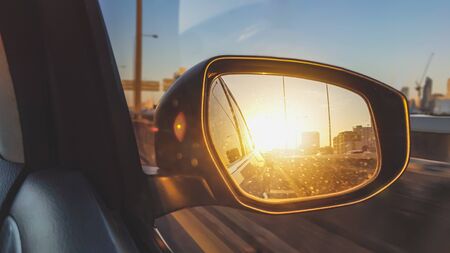 Close up of dirty car mirror or side rear view mirror with reflection of beautiful sunriseの写真素材