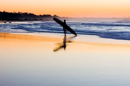 Silhouette of surfer at sunsetの写真素材