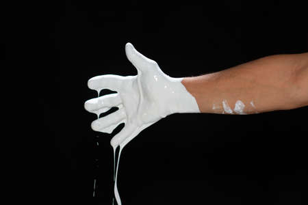 The hands of a man in white paint on a black backgroundの写真素材