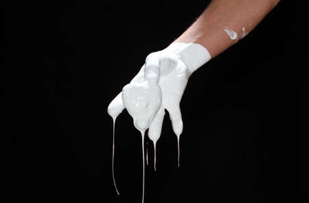 The hands of a man in white paint on a black backgroundの写真素材