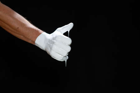 The hands of a man in white paint on a black backgroundの写真素材