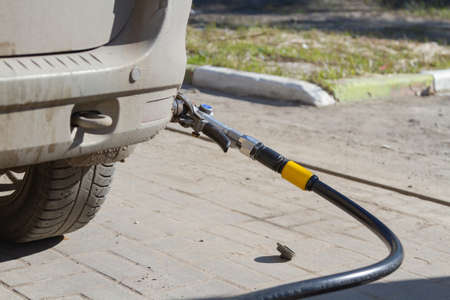 Technicians operating using safe equipment to refuel ngv, lpg, cng gas into the car valve point of...