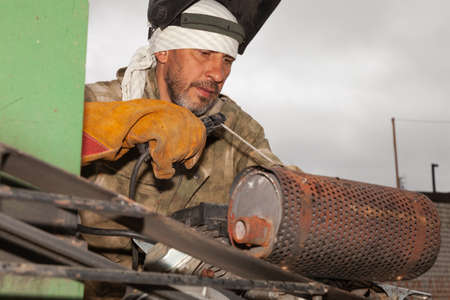 Welder. A worker repair machinery. A man is doing repair work.