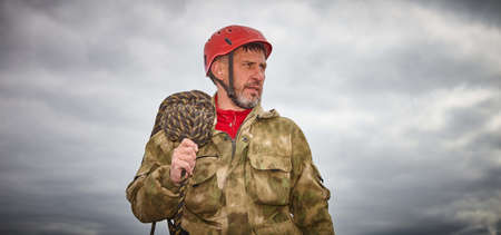 The man is a builder. A man at a hard job. The installer in the helmet. A man and a cloudy sky. A...