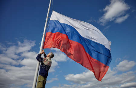 The Russian flag in the wind. The flag of Russia on the flagpole