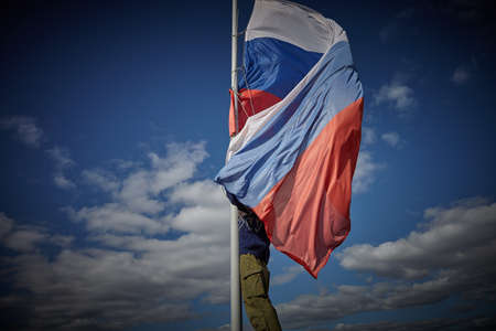 The Russian flag in the wind. The flag of Russia on the flagpole