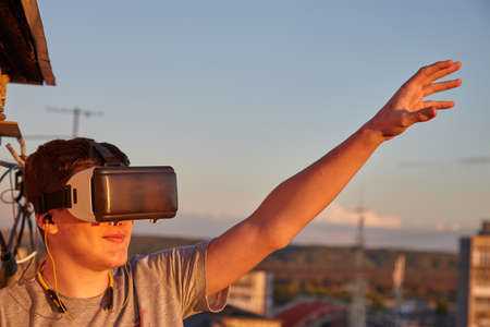 The guy in the virtual glasses. The boy looks into the virtual world. The guy admires the virtual...