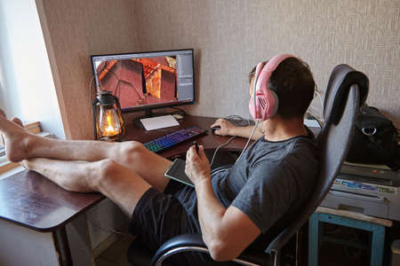 A man retouches a photo at home at the computer.