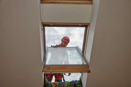 Exit to the roof from the attic. The installer exits through the sunroof.