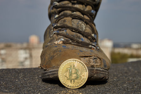 Bitcoin and shoe. A digital finance system and an old work boot.