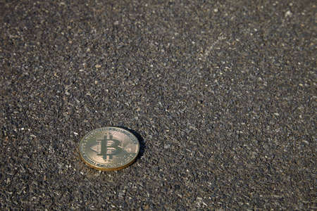 Bitcoin Coin Lies on Black Sandの写真素材