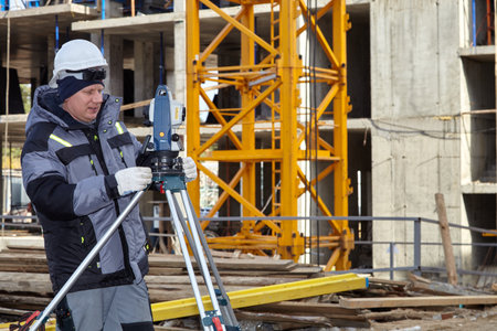 Work with theodolite. An engineer works with a theodolite on a construction site.のeditorial素材